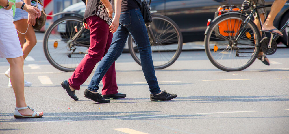 Radfahrer und Fußgänger überqueren die Straße