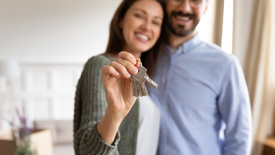 Ehepaar mit Wohnungsschlüssel in der Hand